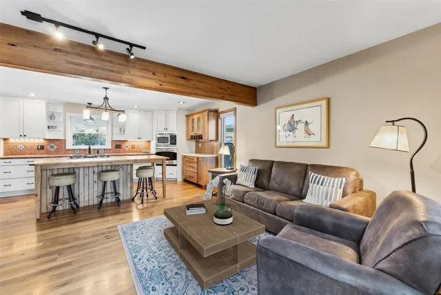 a living room with furniture a rug and wall paintings