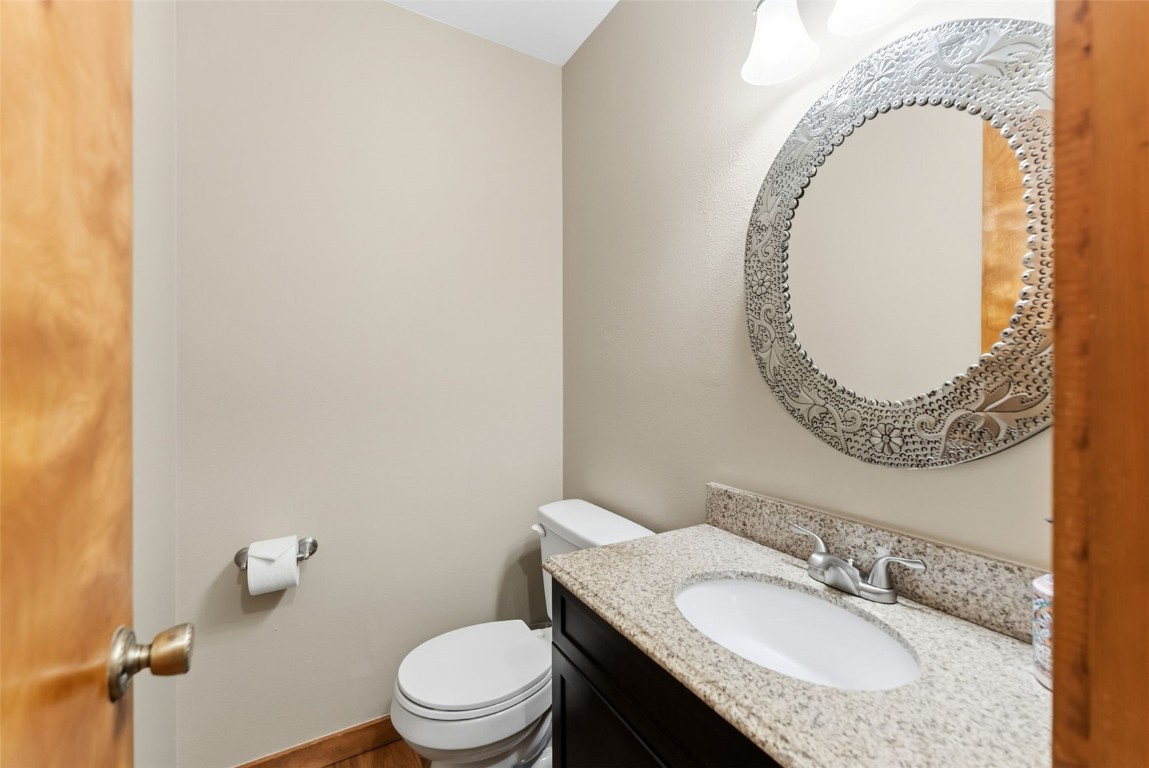 994 Summit Drive Dillon, CO 80435 - Photo 19 of 38 a bathroom with a granite countertop toilet a sink and a mirror