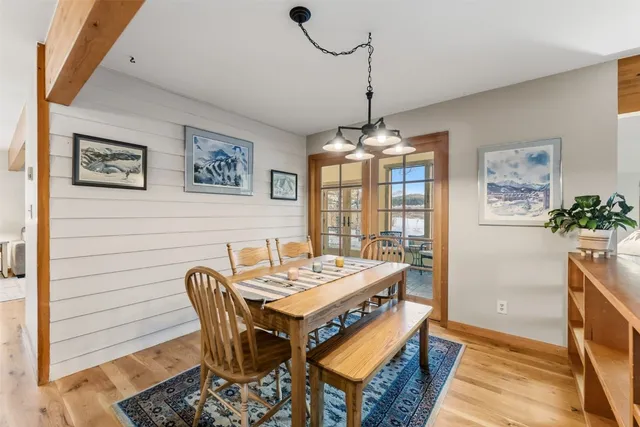 a view of a dining room with furniture a chandelier and wooden floor