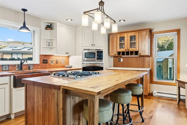 a kitchen with stainless steel appliances a dining table and chairs