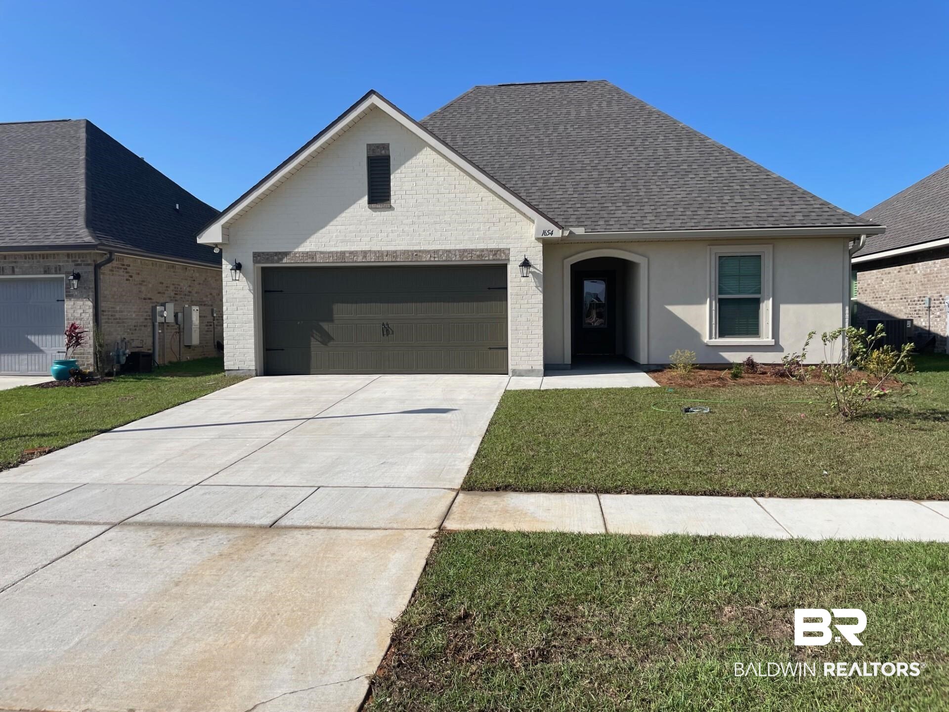 1654 Fenton Circle Foley, AL 36535 - Photo 1 of 3 View of front of property with a front lawn, driveway, an attached garage, and roof with shingles