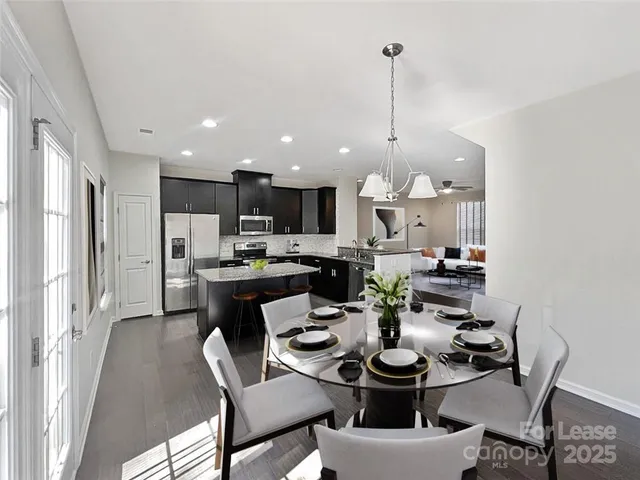 a view of a dining room and livingroom with furniture wooden floor and a rug