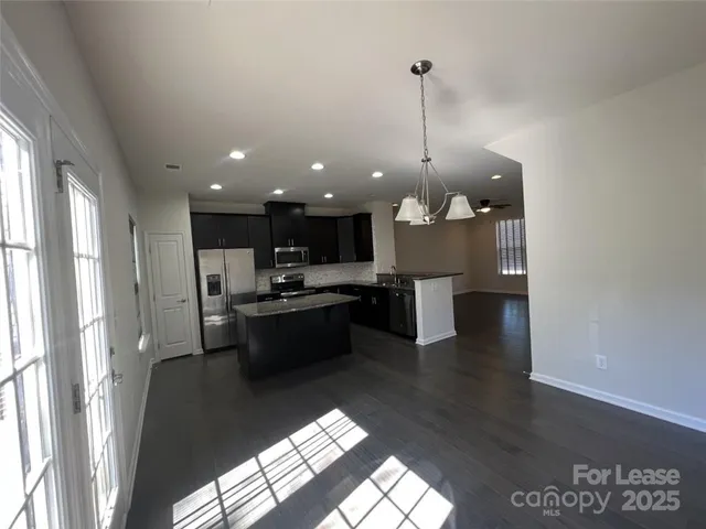 a large kitchen with kitchen island a sink stainless steel appliances and a counter top space