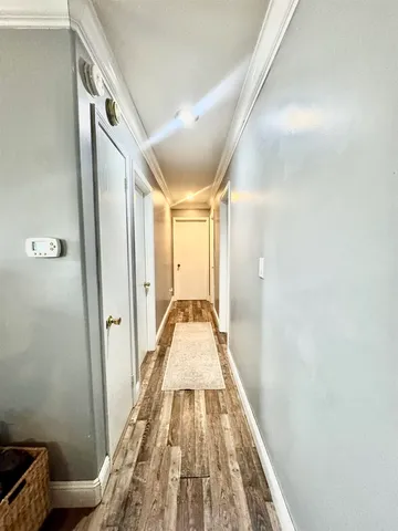 a view of a hallway with wooden floor and staircase