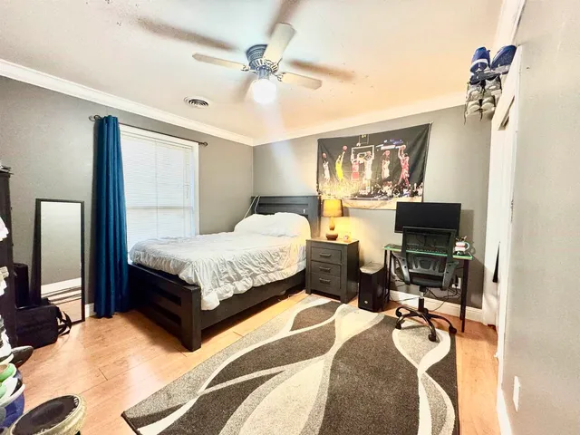 a bedroom with a bed and wooden floor