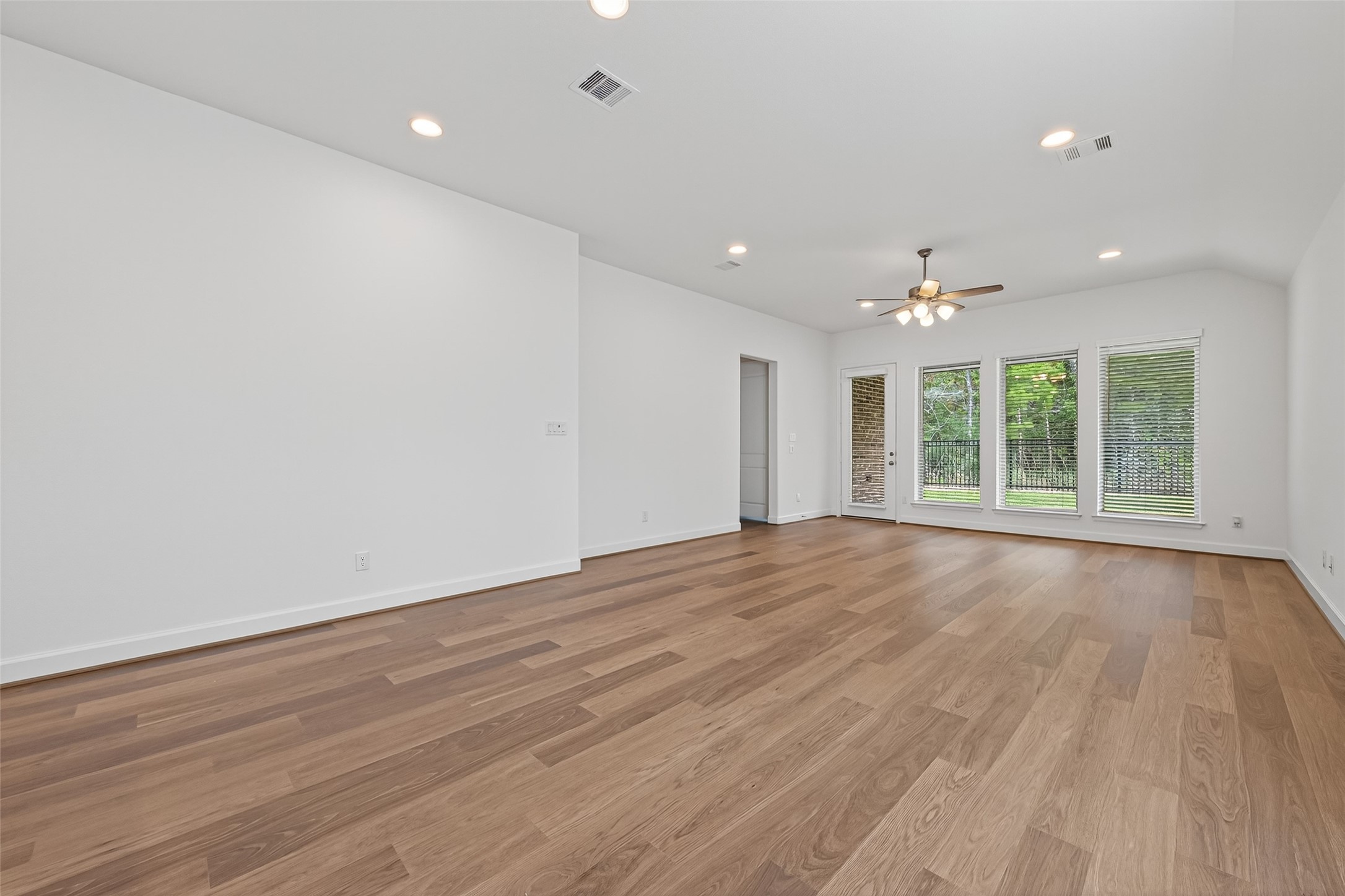122 Sierra Strm Court Conroe, TX 77304 - Photo 20 of 40 an empty room with wooden floor and windows