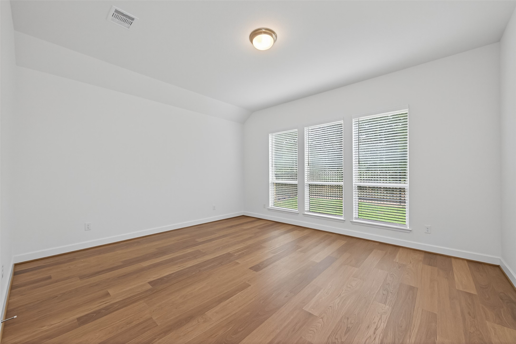 122 Sierra Strm Court Conroe, TX 77304 - Photo 25 of 40 an empty room with wooden floor and windows