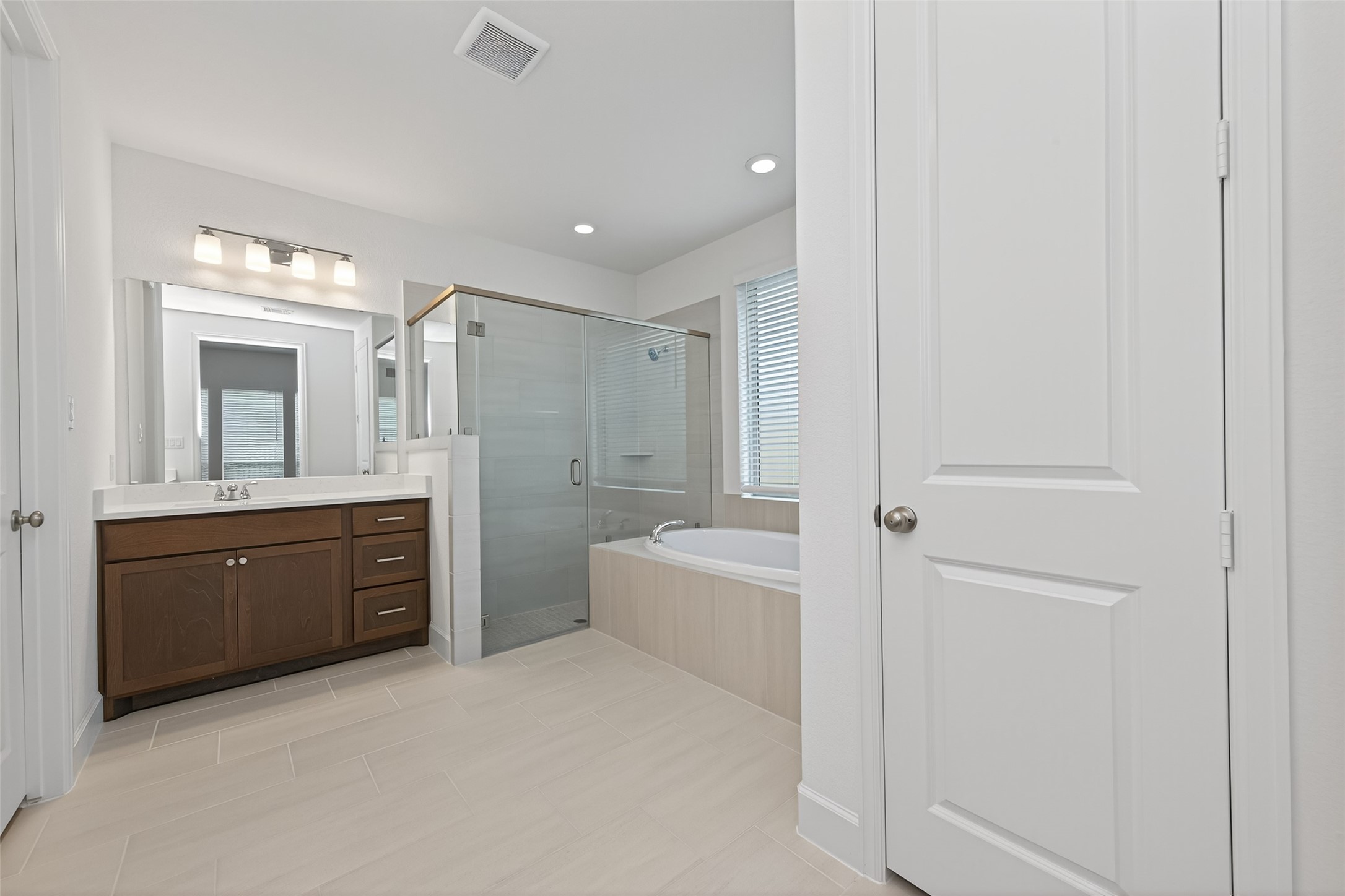 122 Sierra Strm Court Conroe, TX 77304 - Photo 29 of 40 a spacious bathroom with a mirror a sink and a bathtub