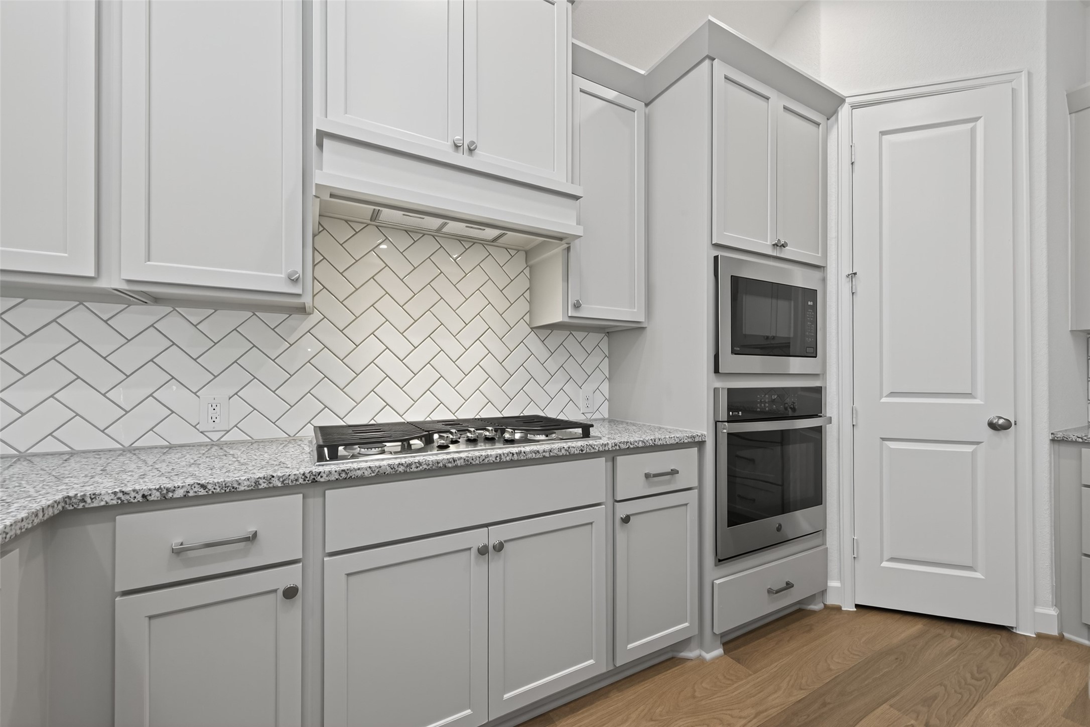 122 Sierra Strm Court Conroe, TX 77304 - Photo 10 of 40 a kitchen with granite countertop white cabinets and white appliances