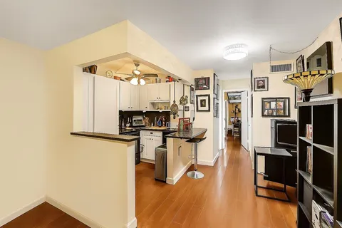 a living room with stainless steel appliances furniture and a view of kitchen