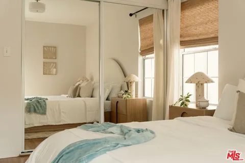 a bedroom with a large bed and a chandelier