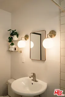 a bathroom with a sink mirror and toilet