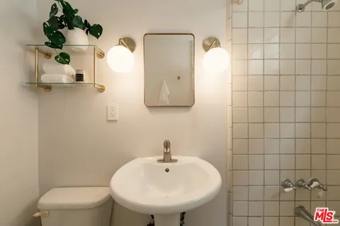 a bathroom with a sink a toilet and mirror