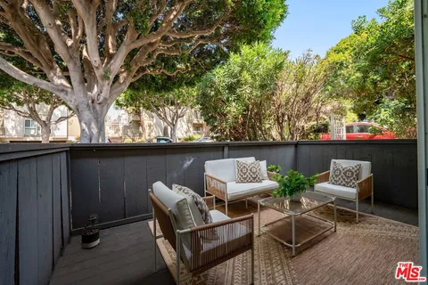 a view of backyard with seating space and trees