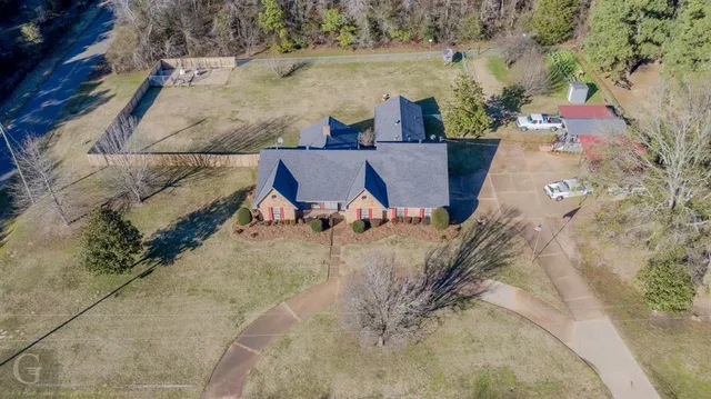 an aerial view of a house with a yard and lake view