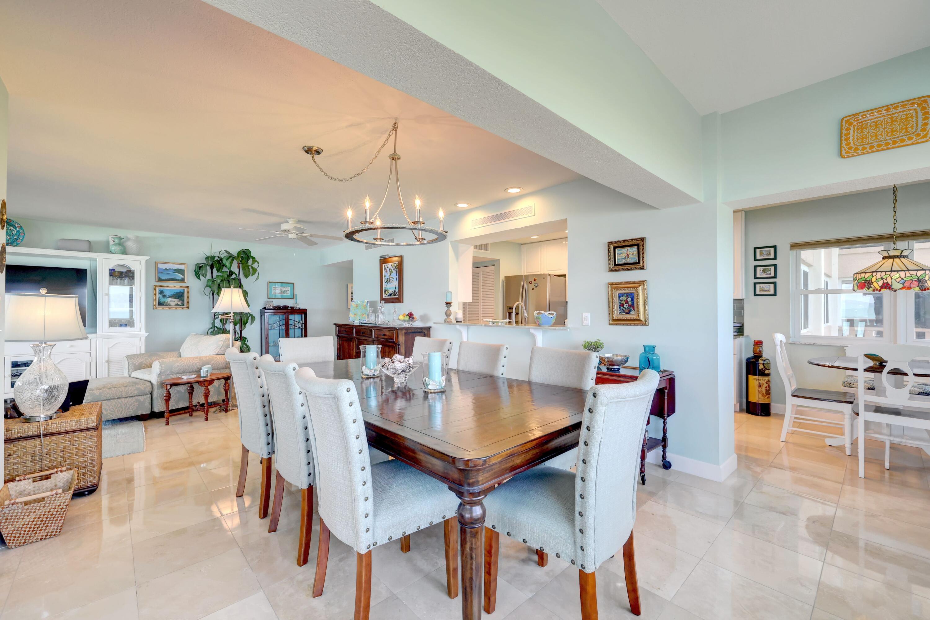 1555 Northeast Ocean Boulevard, Unit 205 Stuart, FL 34996 - Photo 16 of 57 a view of a dining room and livingroom with furniture wooden floor a rug a painting and a chandelier