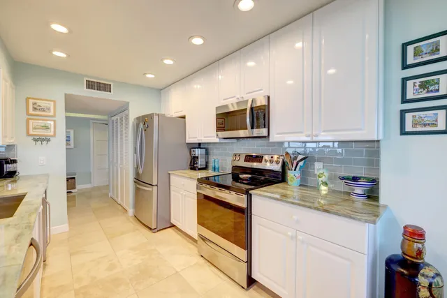 a large bedroom with a bed a couch and a flat tv screen on dresser