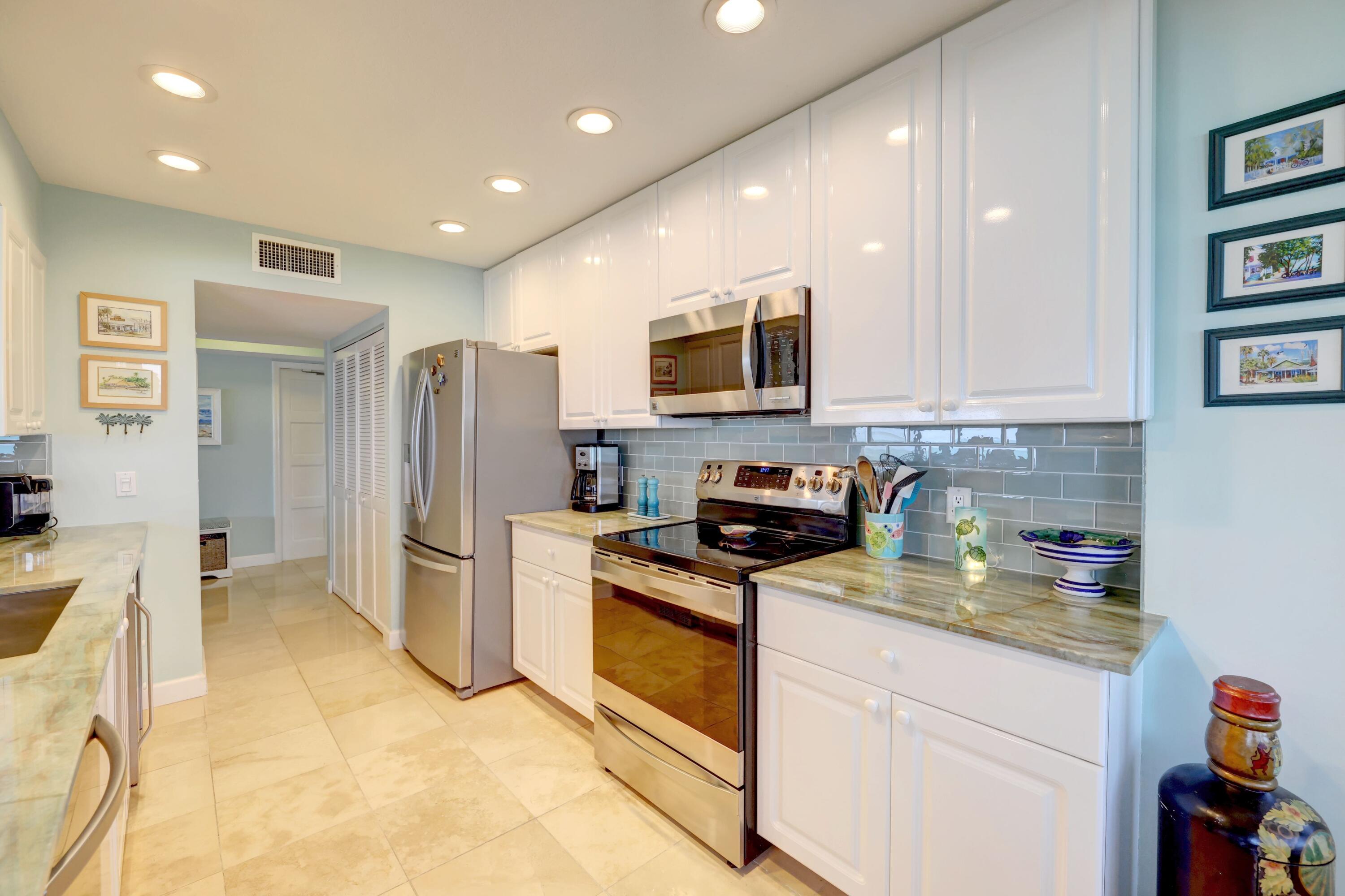 1555 Northeast Ocean Boulevard, Unit 205 Stuart, FL 34996 - Photo 21 of 57 a kitchen with a refrigerator and a stove top oven