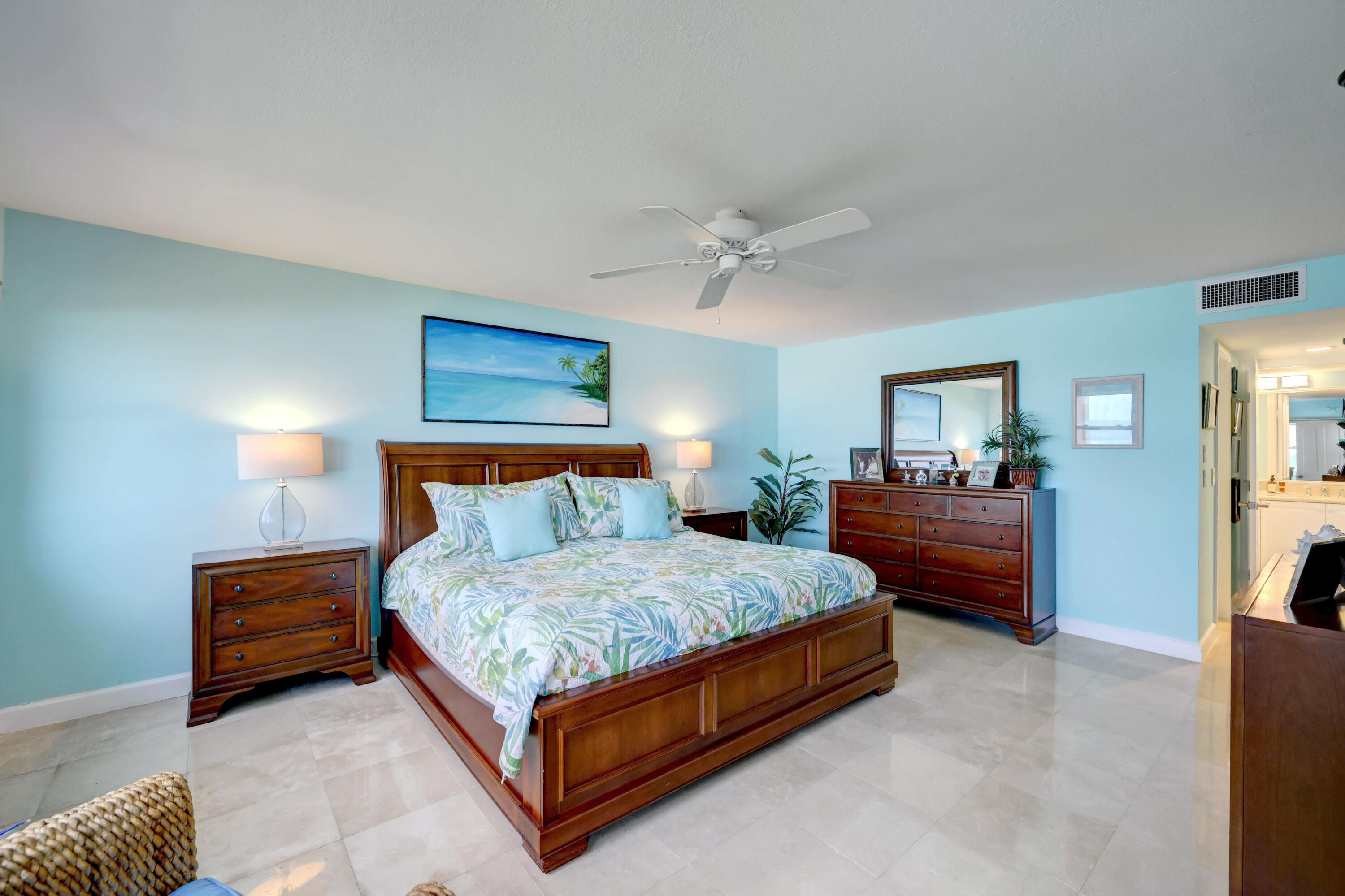 1555 Northeast Ocean Boulevard, Unit 205 Stuart, FL 34996 - Photo 25 of 57 a spacious bedroom with a bed and a chandelier