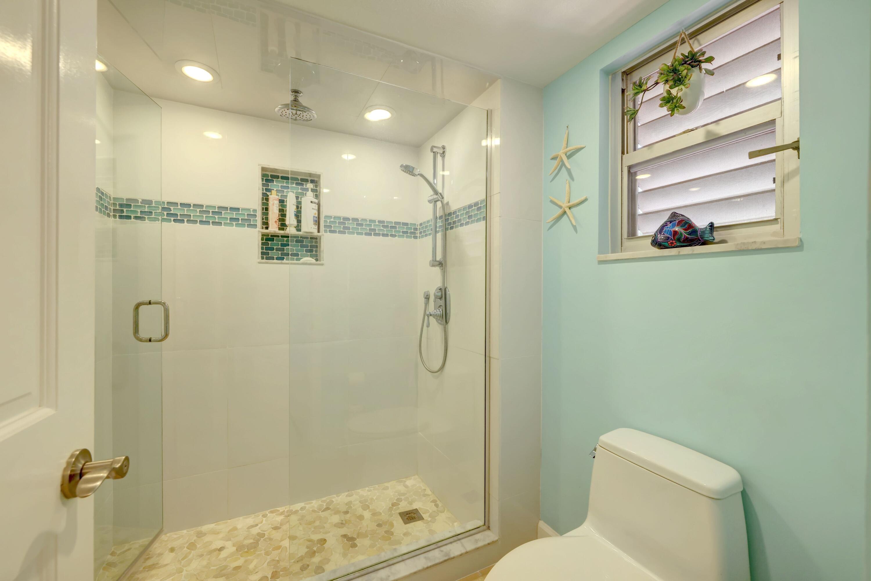 1555 Northeast Ocean Boulevard, Unit 205 Stuart, FL 34996 - Photo 27 of 57 a bathroom with a shower a toilet and a shower