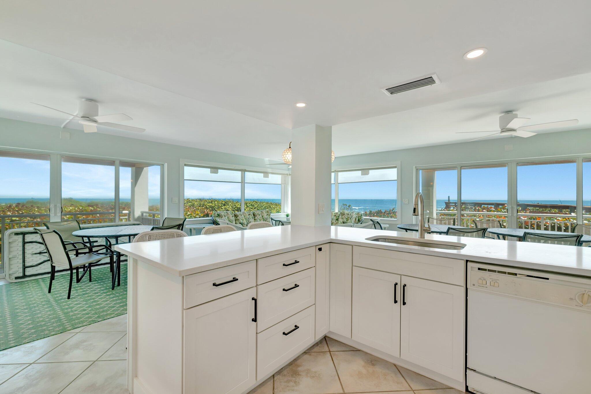 1555 Northeast Ocean Boulevard, Unit 205 Stuart, FL 34996 - Photo 55 of 57 a kitchen with white cabinets and chairs