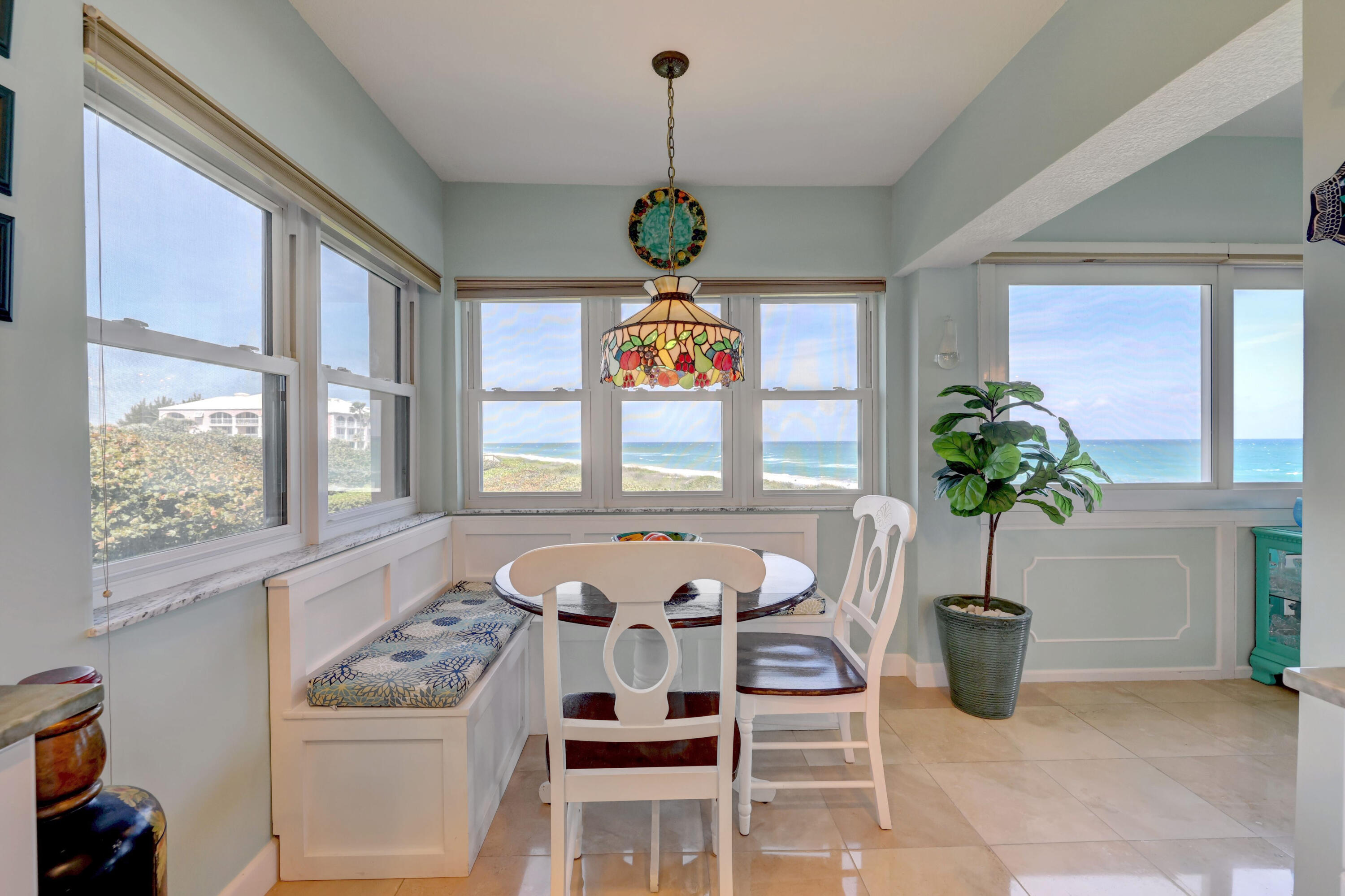 1555 Northeast Ocean Boulevard, Unit 205 Stuart, FL 34996 - Photo 7 of 57 a vase of flowers sitting on a table in front of a window