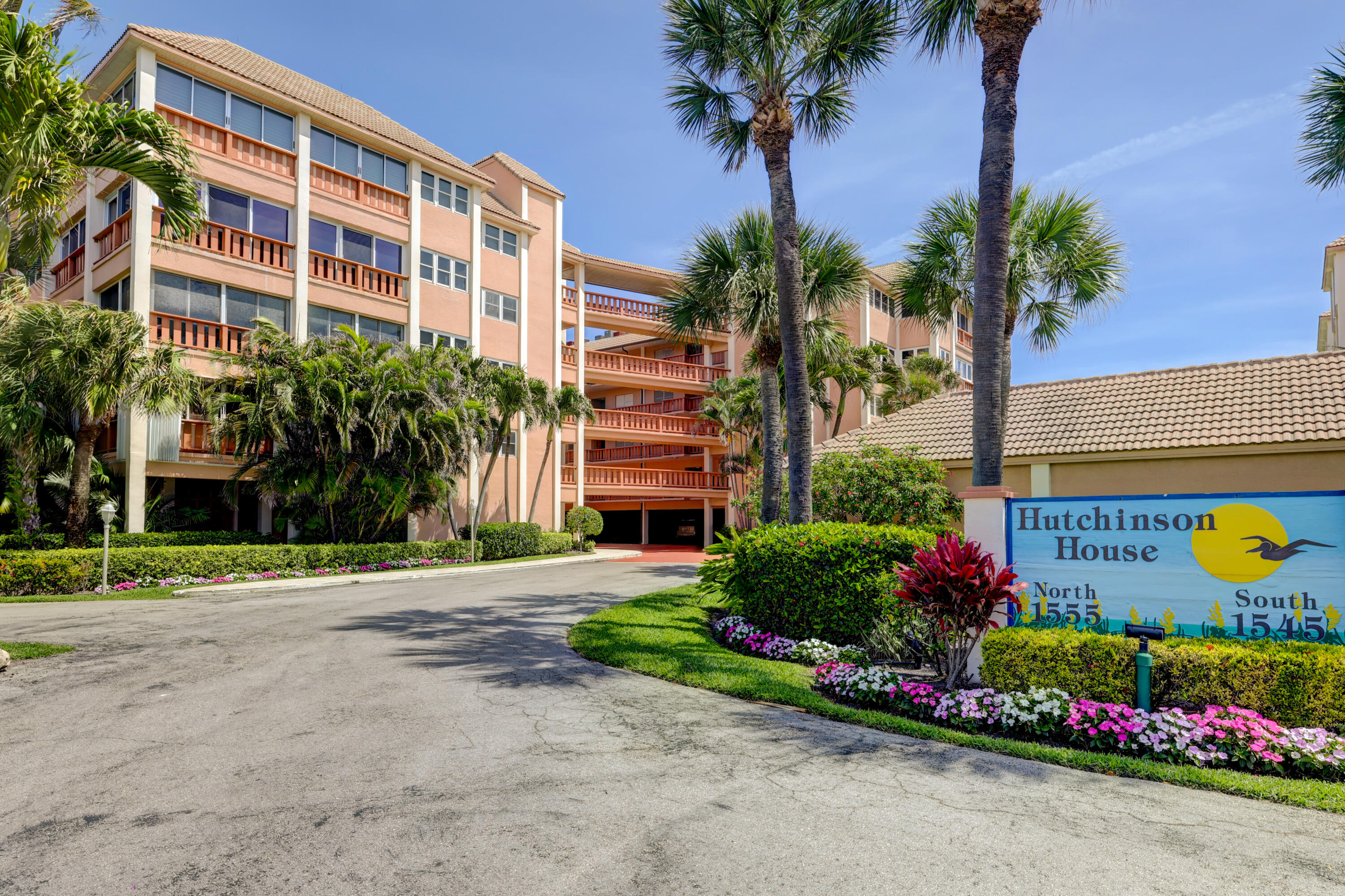 1555 Northeast Ocean Boulevard, Unit 205 Stuart, FL 34996 - Photo 9 of 57 a front view of multi story residential apartment building with yard and flowers