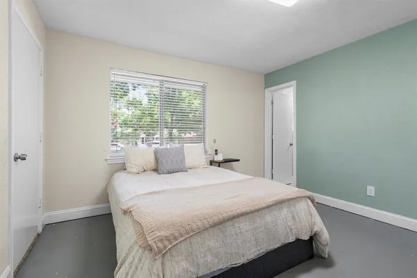 a bedroom with a bed and a window