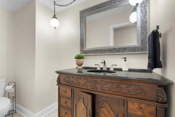 a bathroom with a granite countertop sink a toilet and mirror