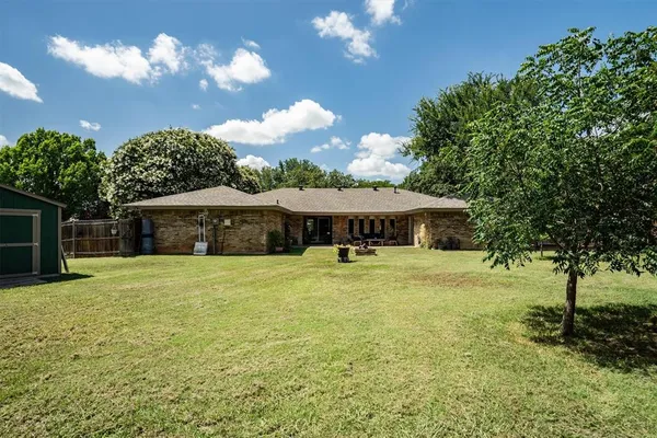 a view of a house with a yard and basketball court