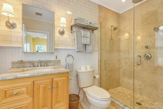 a bathroom with a granite countertop sink toilet mirror and shower