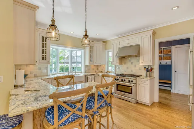 a view of a dining room and livingroom with furniture wooden floor a chandelier