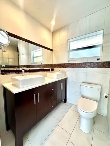 a bathroom with a sink mirror vanity and toilet