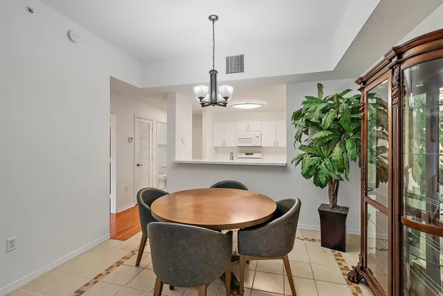 a dining room with furniture and potted plant