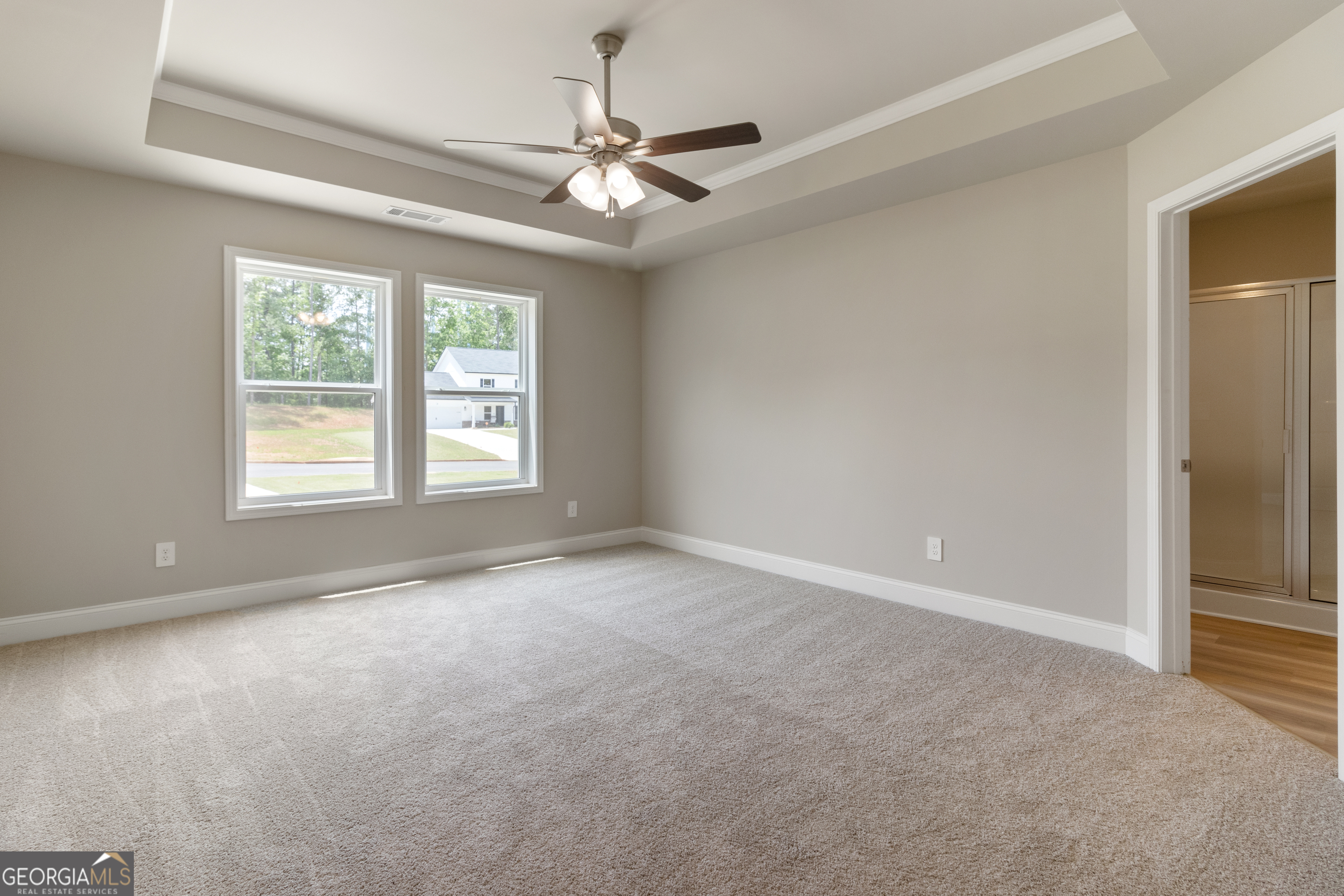 215 Davis Lake Road Thomaston, GA 30286 - Photo 17 of 29 an empty room with a ceiling fan and windows