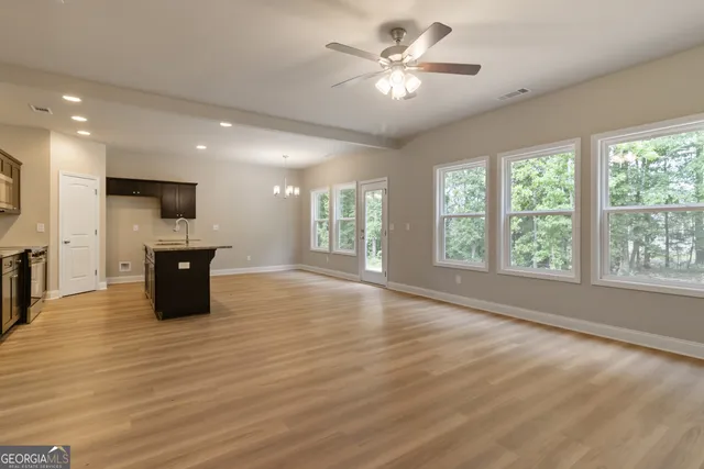 an empty room with a flat screen tv and a large window