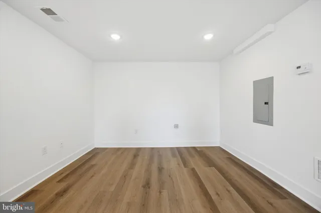 a view of room with wooden floor and white walls