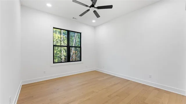 an empty room with a window and a fan
