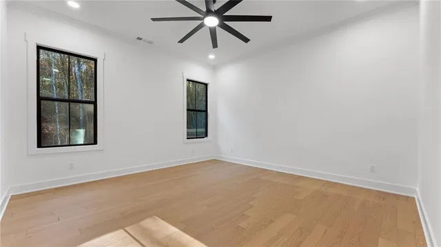 an empty room with windows and fan