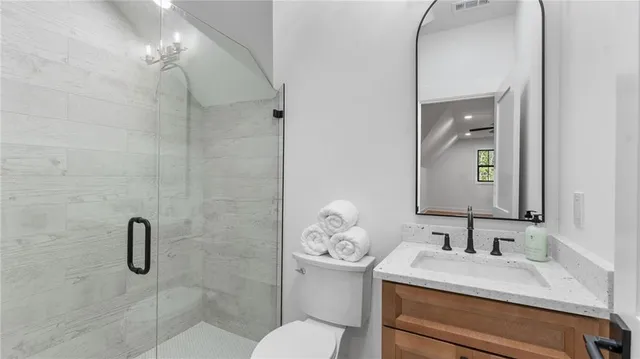 a bathroom with a granite countertop sink a toilet and a mirror