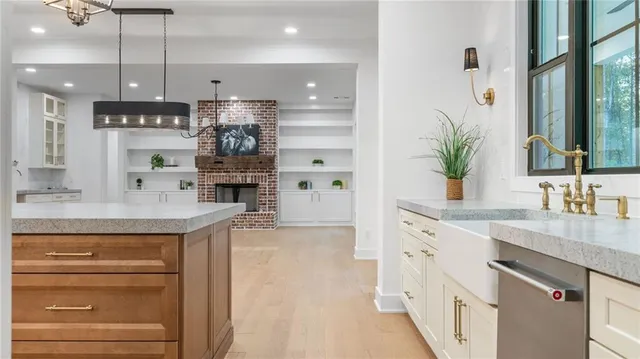 a kitchen with kitchen island granite countertop a sink stainless steel appliances and cabinets