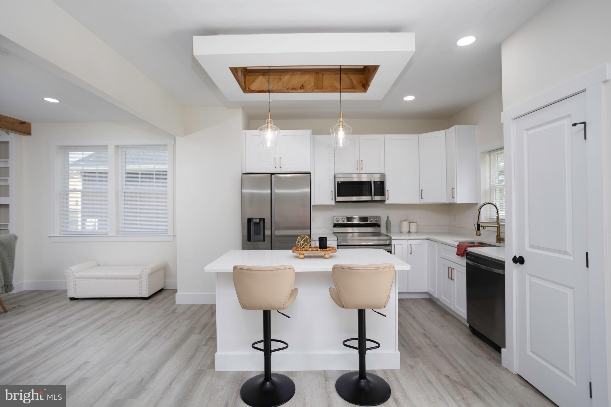 10 Sunrise Avenue Ridgely, MD 21660 - Photo 9 of 21 a kitchen with stainless steel appliances kitchen island granite countertop a sink dishwasher stove and white cabinets with wooden floor