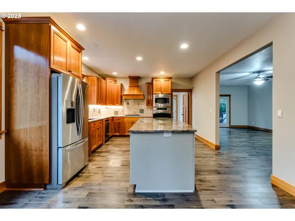 a kitchen with stainless steel appliances granite countertop a refrigerator and a stove