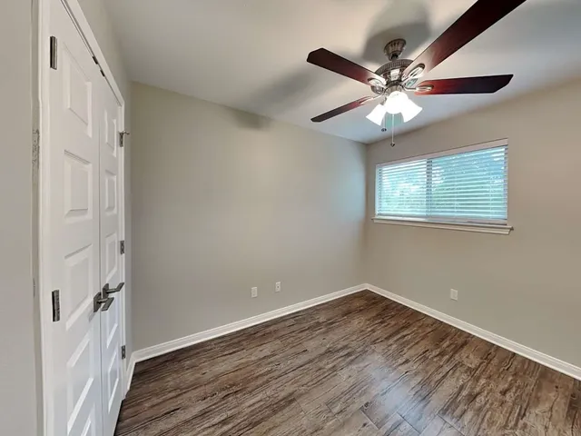 a view of a room with wooden floor closet and windows