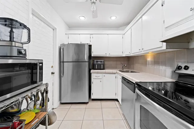 a kitchen with stainless steel appliances granite countertop a refrigerator a stove a sink and a stove