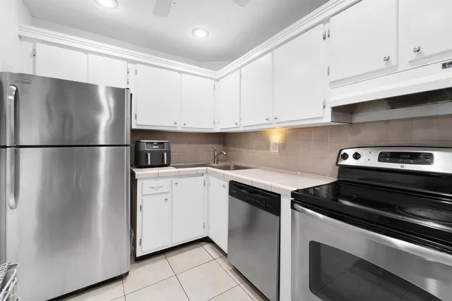 a kitchen with a refrigerator sink and cabinets