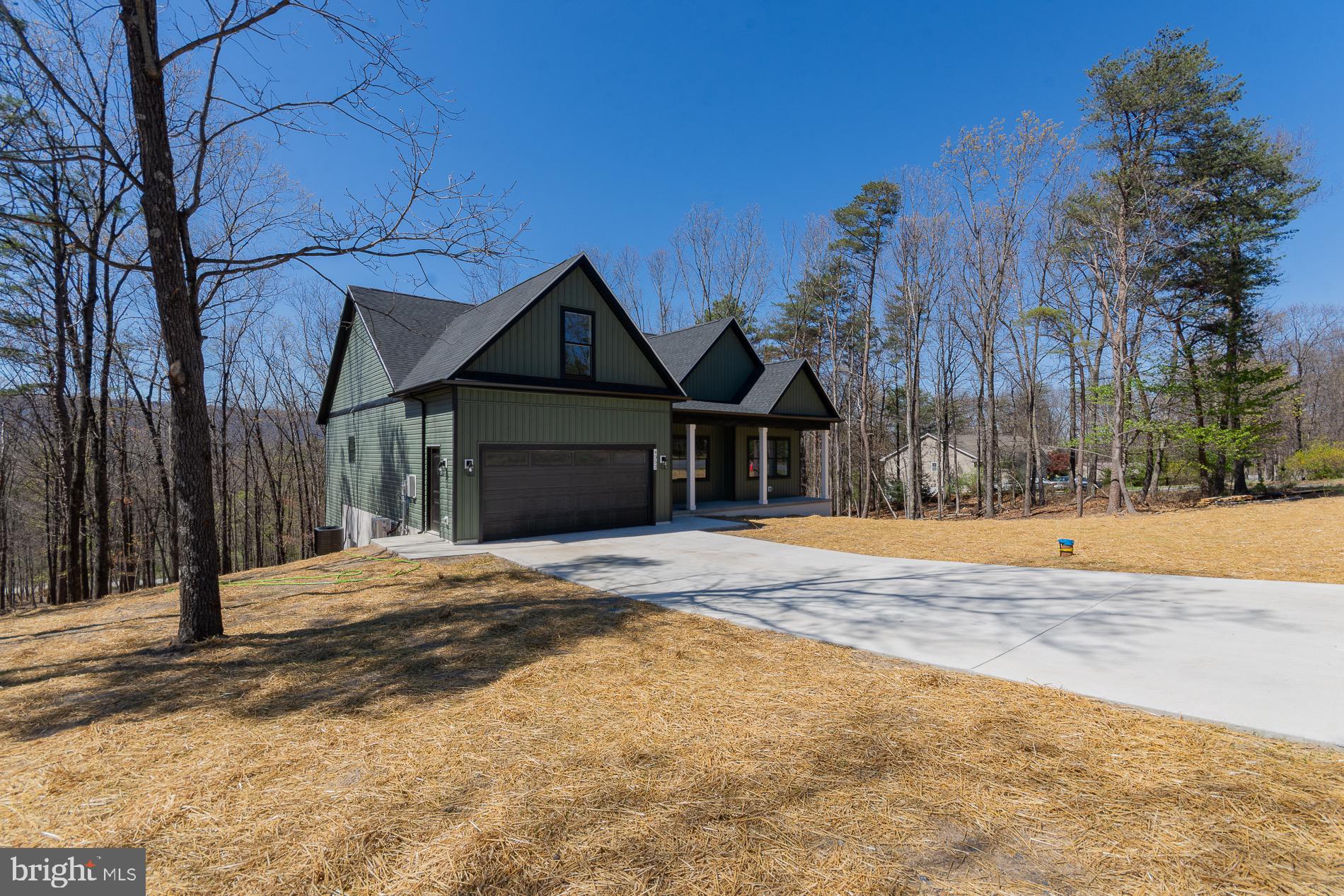 a front view of a house with a yard and trees