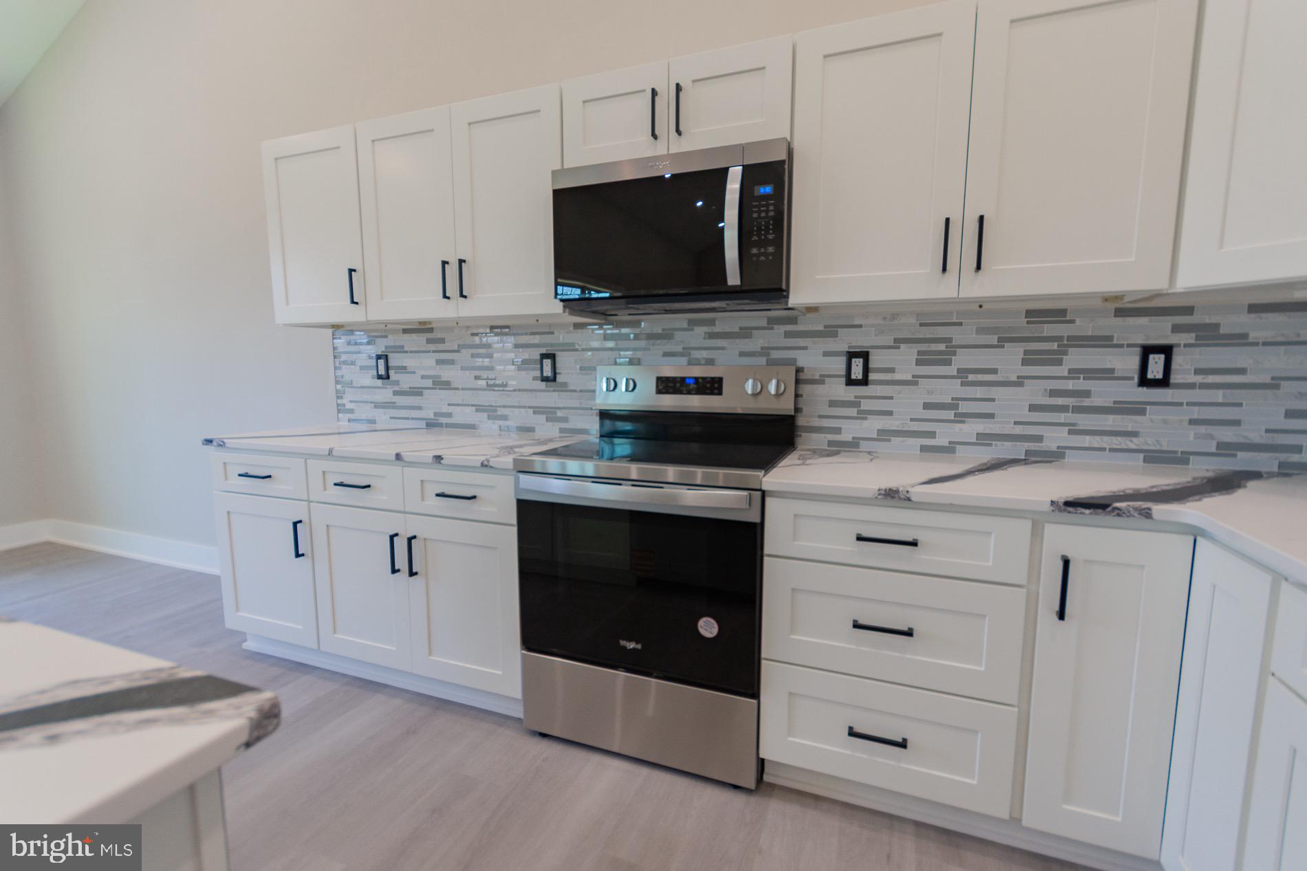 4352 Timber Ridge Road Berkeley Springs, WV 25411 - Photo 54 of 85 a kitchen with stainless steel appliances white cabinets and a stove top oven