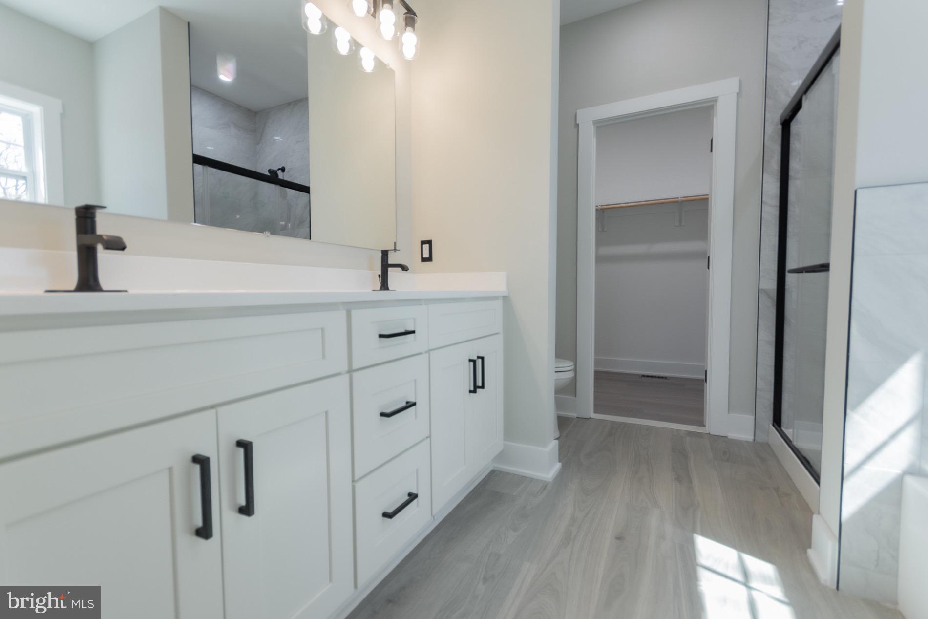 4352 Timber Ridge Road Berkeley Springs, WV 25411 - Photo 60 of 85 a spacious bathroom with a double vanity sink a mirror and shower