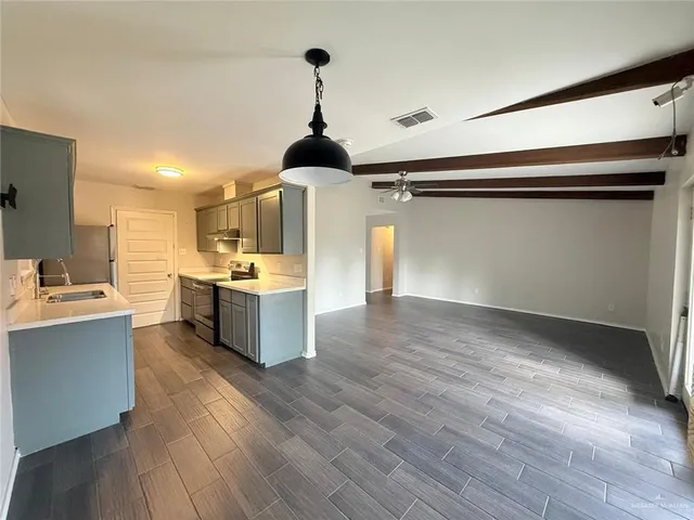 a kitchen with a sink cabinets and wooden floor